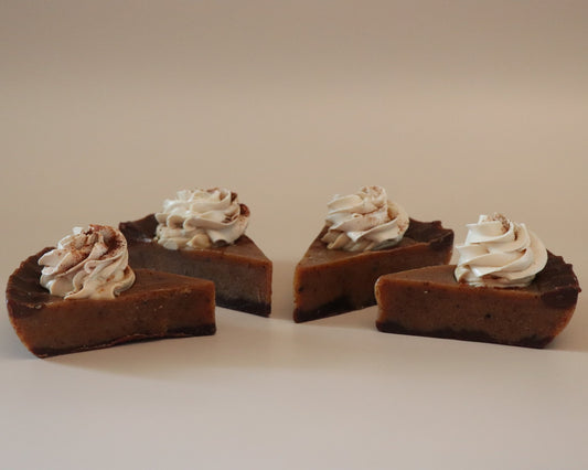 Four slices of chocolate pie with whipped cream on a beige background