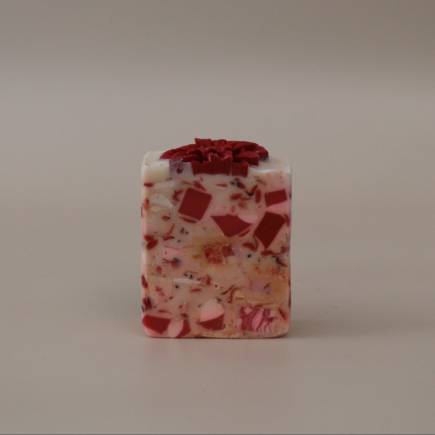 Square-shaped soap with a red top on a beige background