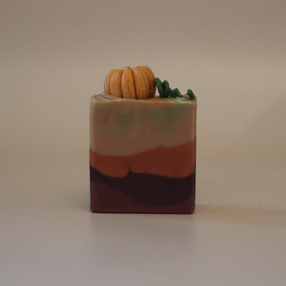 Colorful soap bar with a small pumpkin decoration on it and a beige background
