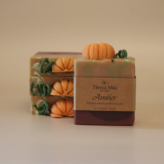 Bar of soap named Amber with pumpkin design and 'Tierra Mia" branding on a beige background