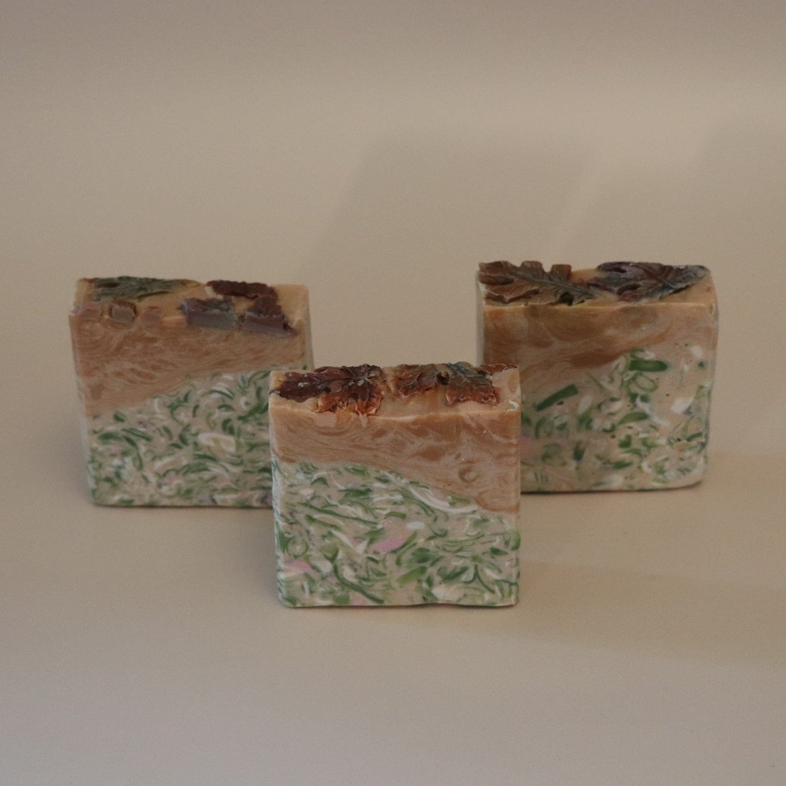 Three decorative stone cubes with natural patterns on a beige background