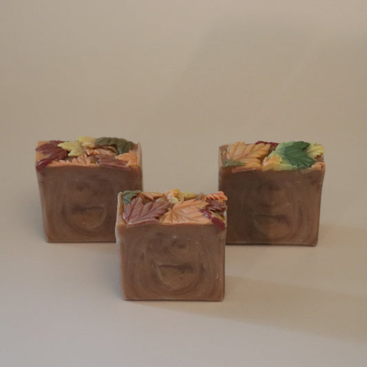 Three square-shaped soap bars with leaf patterns on a beige background