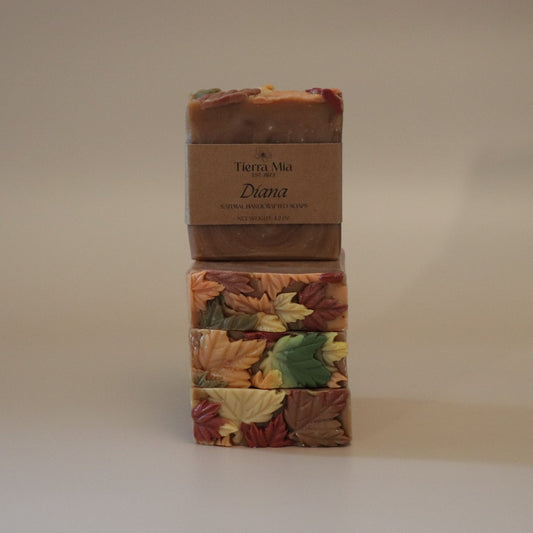 Four soap bars with autumn leaf design and a brown label on a beige background