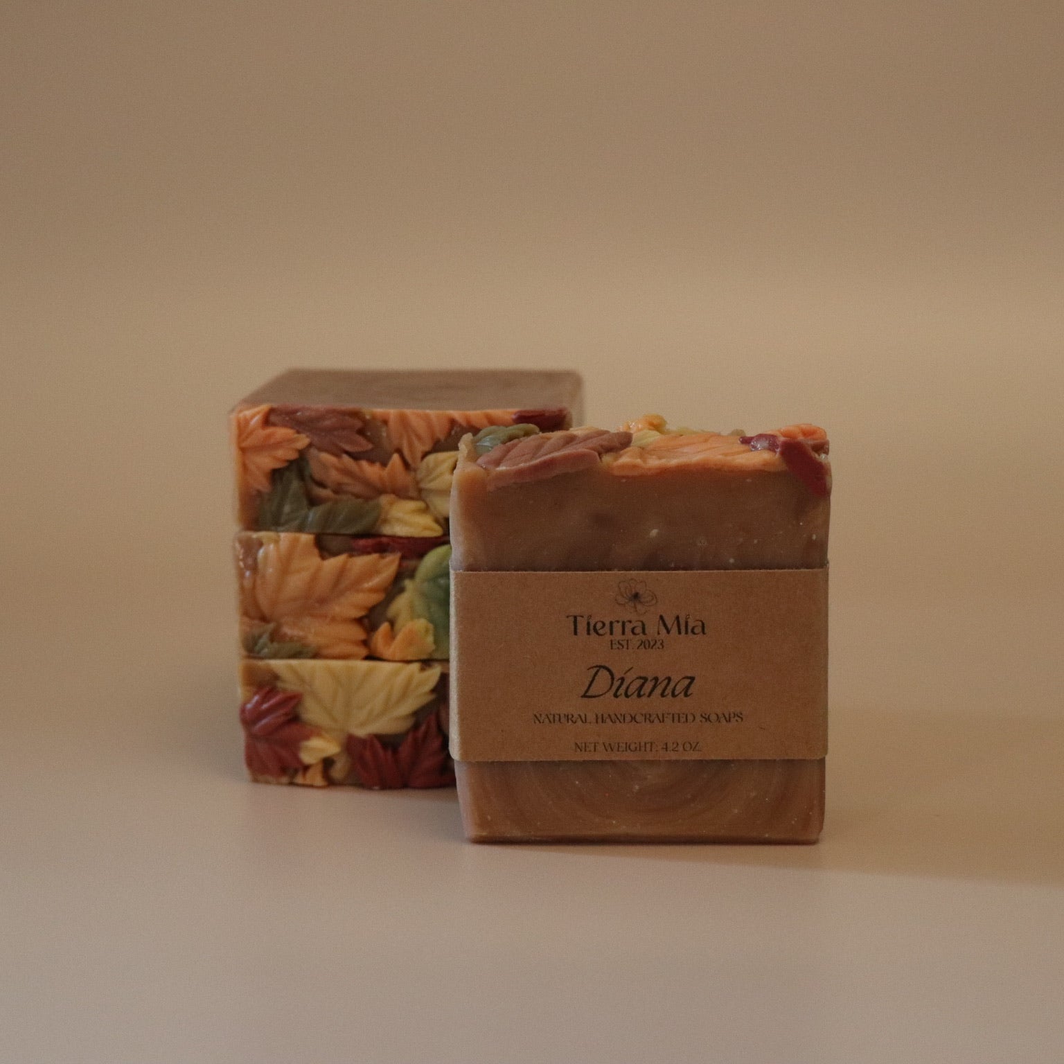 Four soap bars with leaf patterns on a beige background