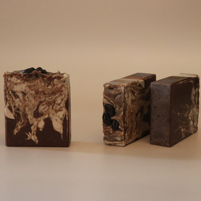 Three bars of brown soap with a marbled pattern on a beige background