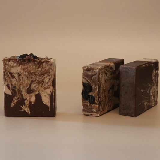 Three bars of brown soap with a marbled pattern on a beige background