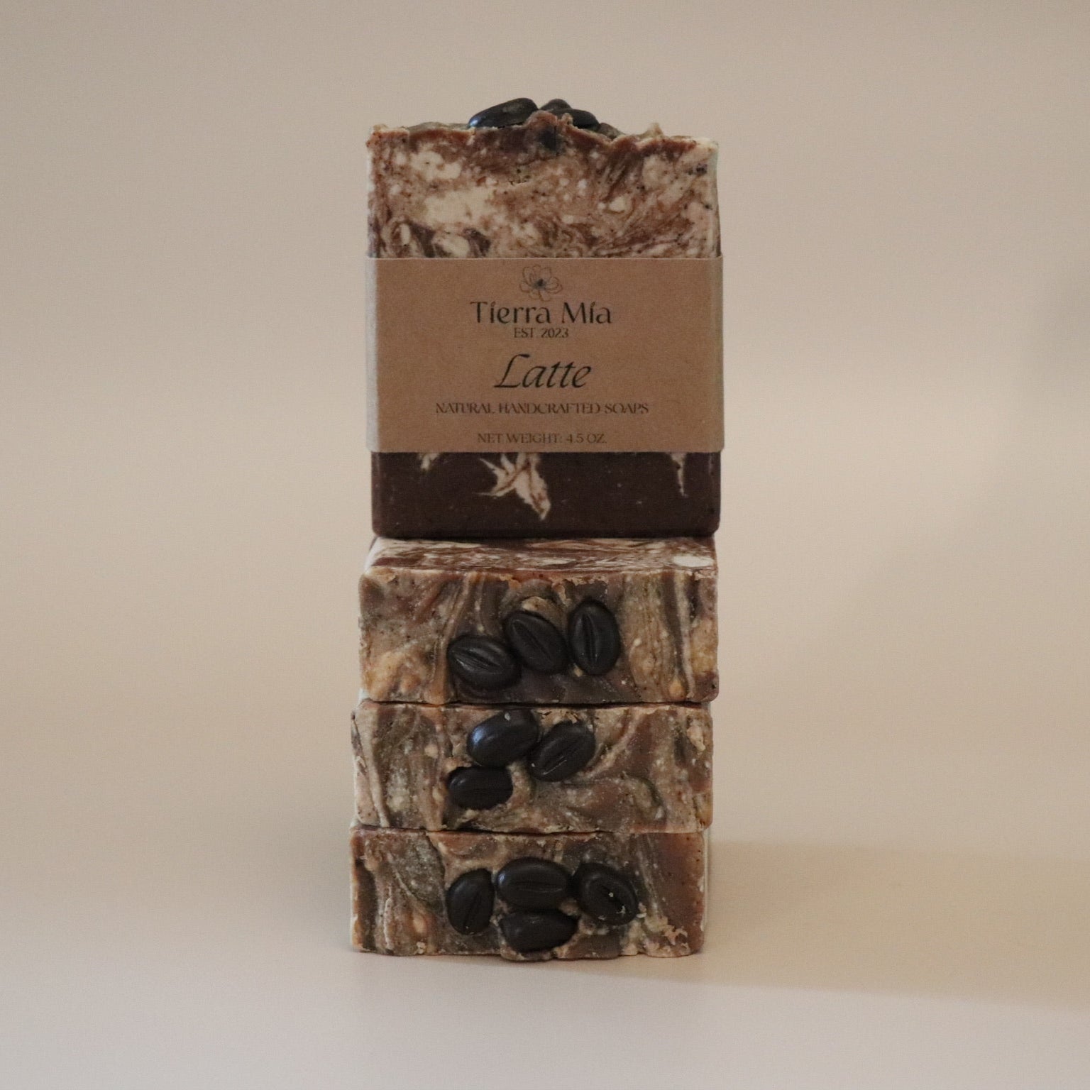 Three stacked soap bars with a brown label on a beige background