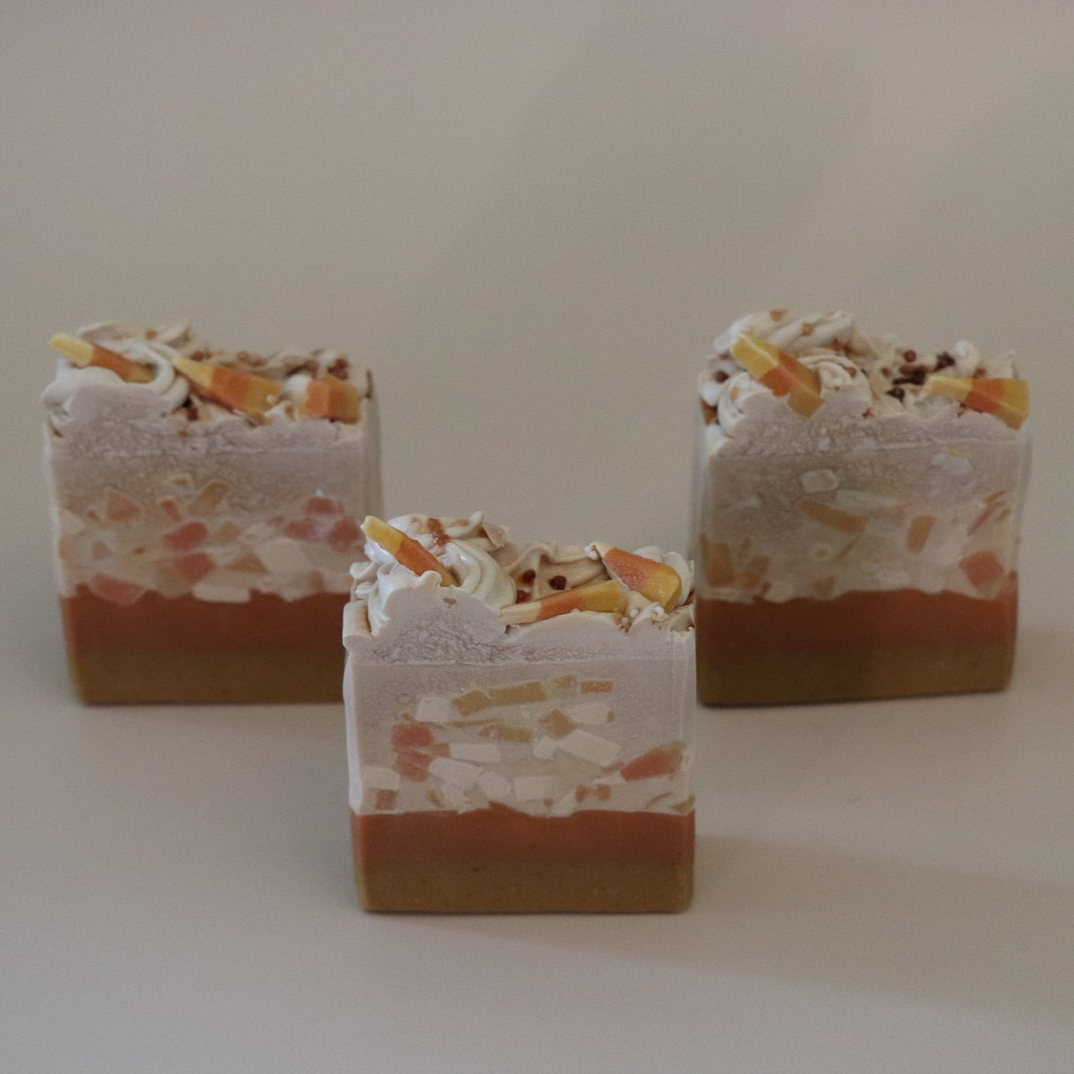 Three layered soap bars with visible layers on a plain background