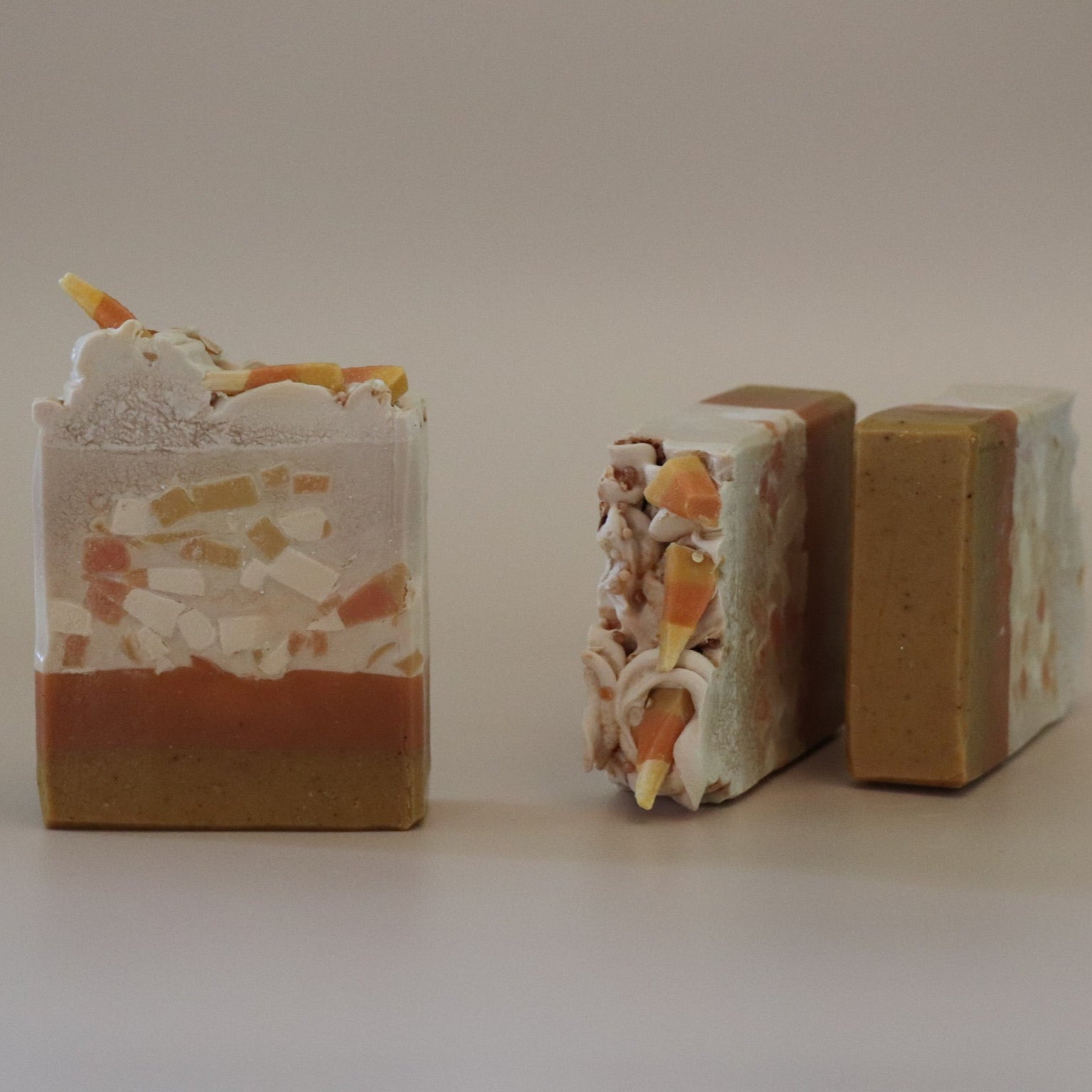 Three soap bars with decorative designs on a plain background