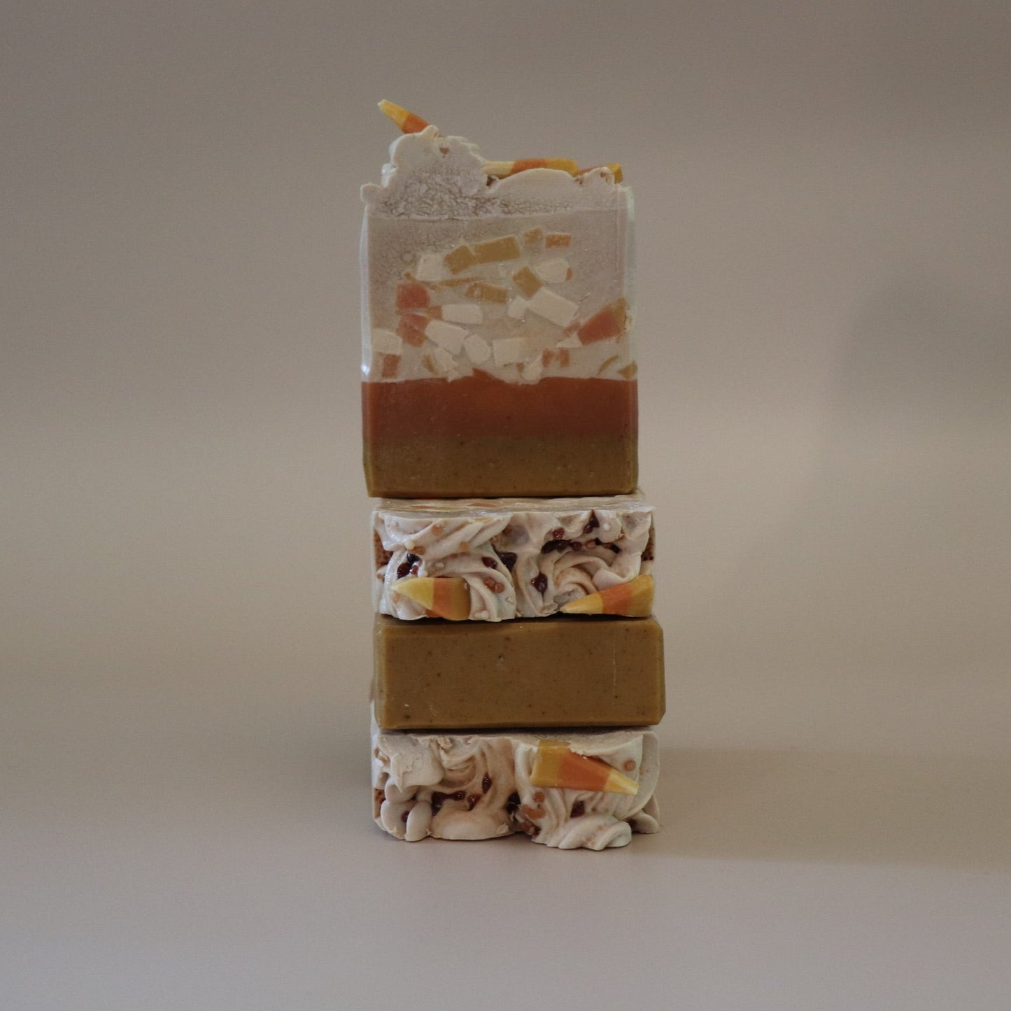 Stack of multicolored soap bars on a neutral background