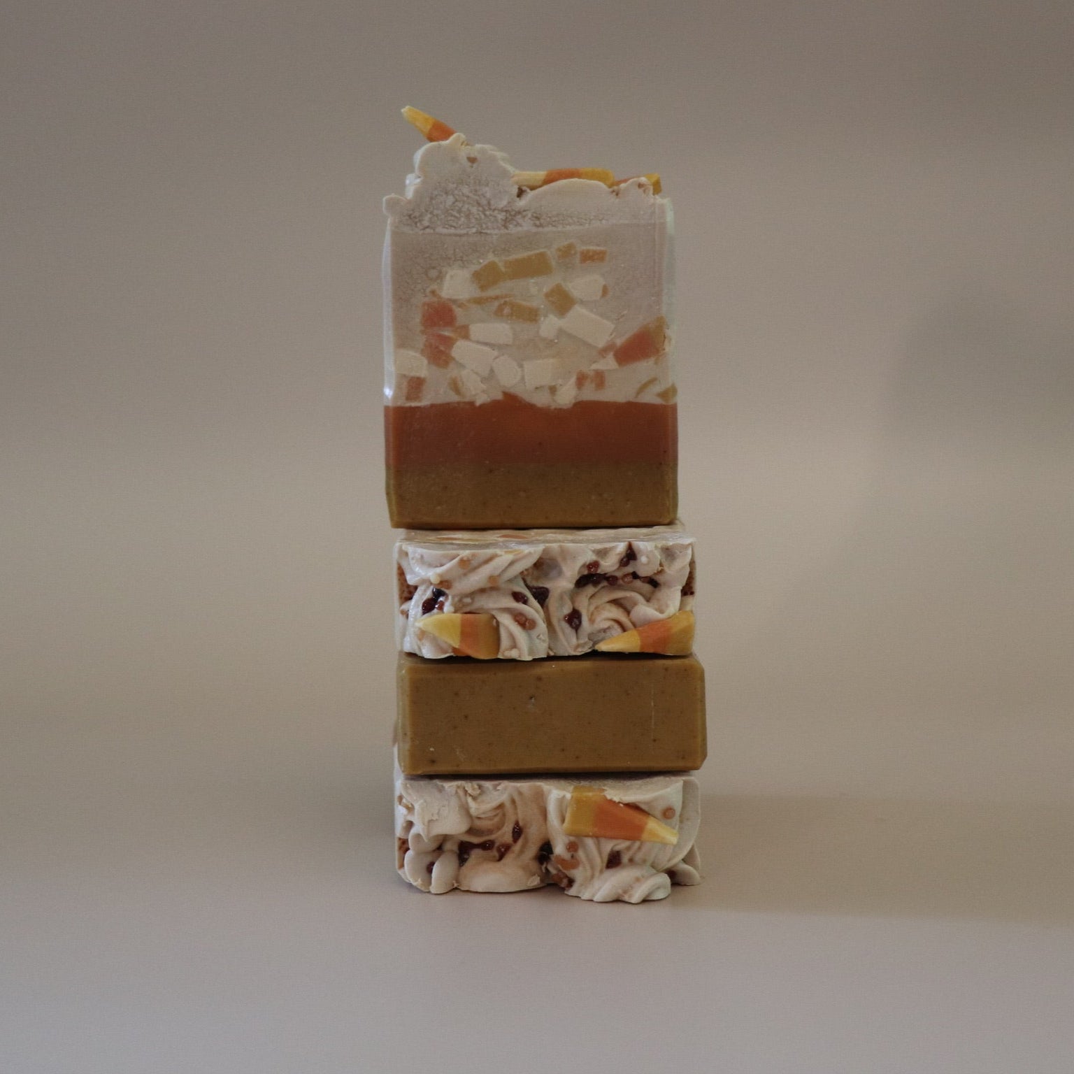 Stack of multicolored soap bars on a neutral background