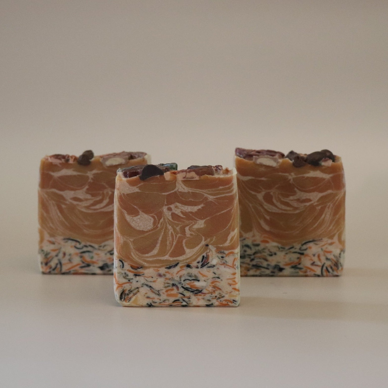 Three swirled soap bars on a plain background