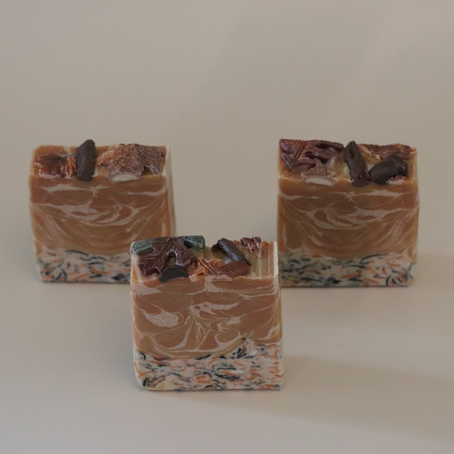 Three bars of soap with a marbled pattern on a plain background