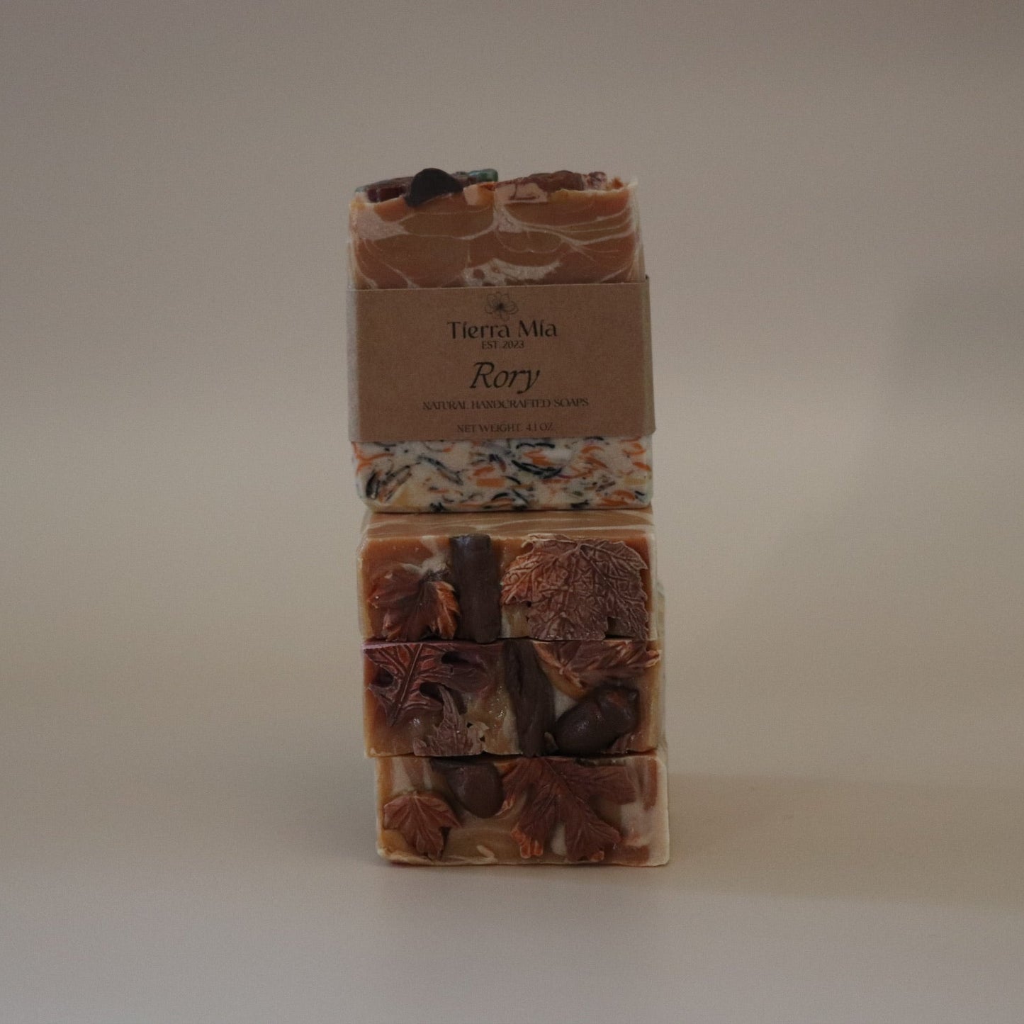 Three stacked soap bars with a label on a beige background