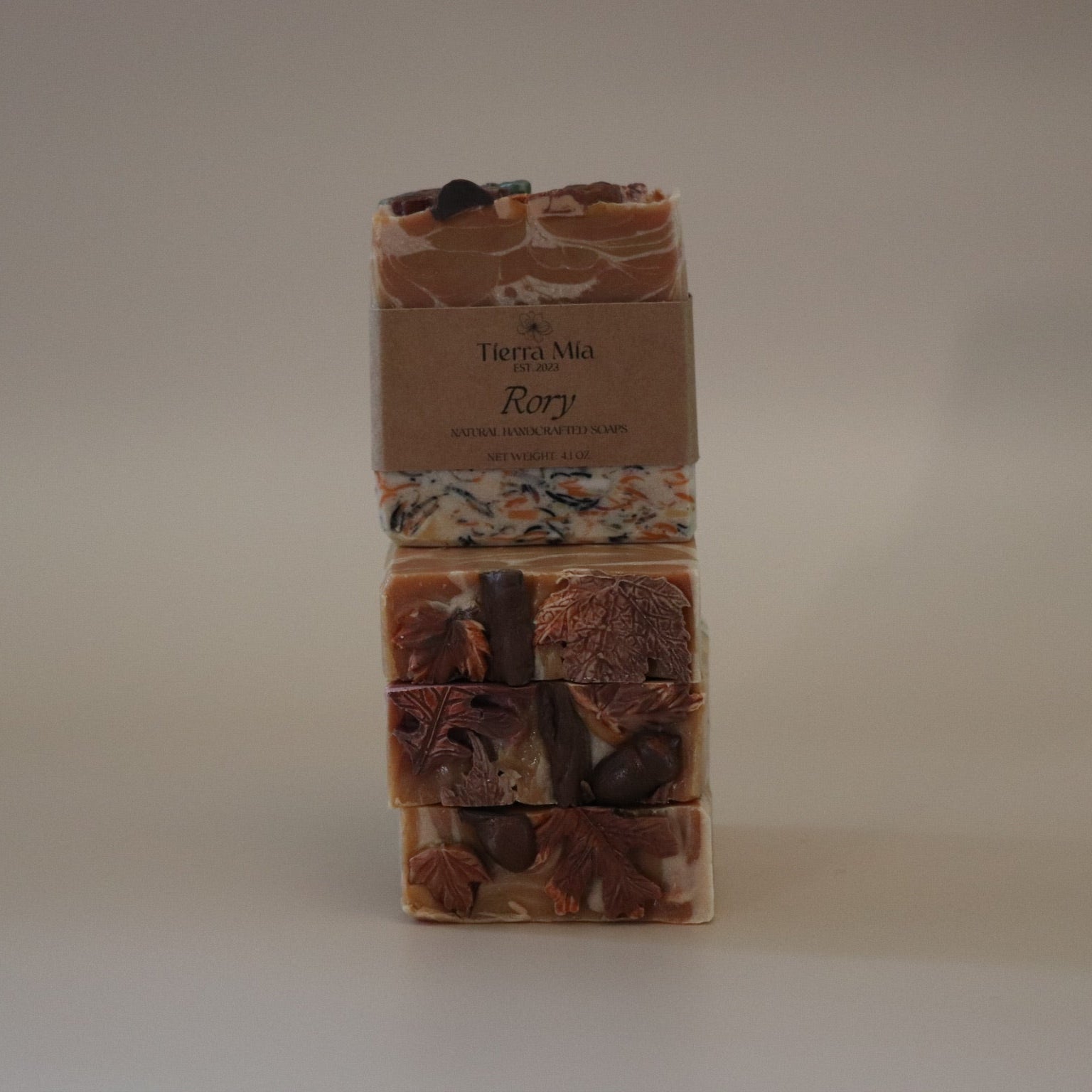 Three stacked soap bars with a label on a beige background