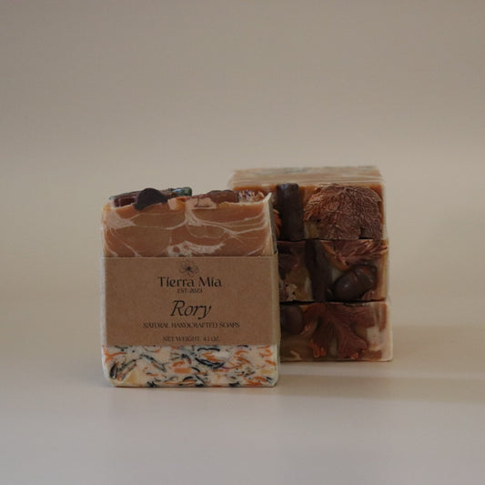 Two soap bars with decorative packaging on a plain background