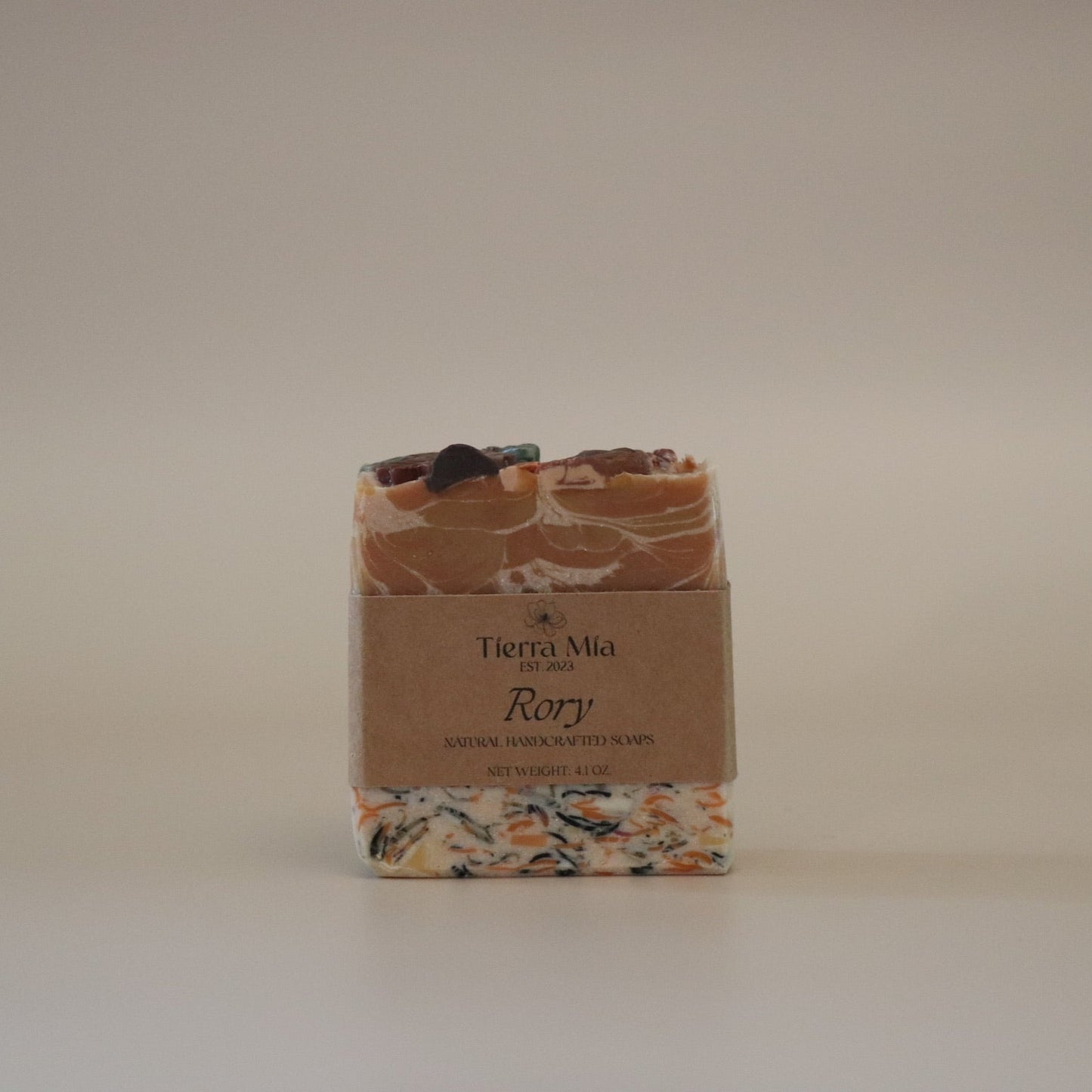Bar of soap with a decorative packaging label on a plain background