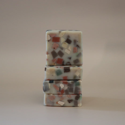 Stack of three terrazzo-patterned soap bars on a plain background