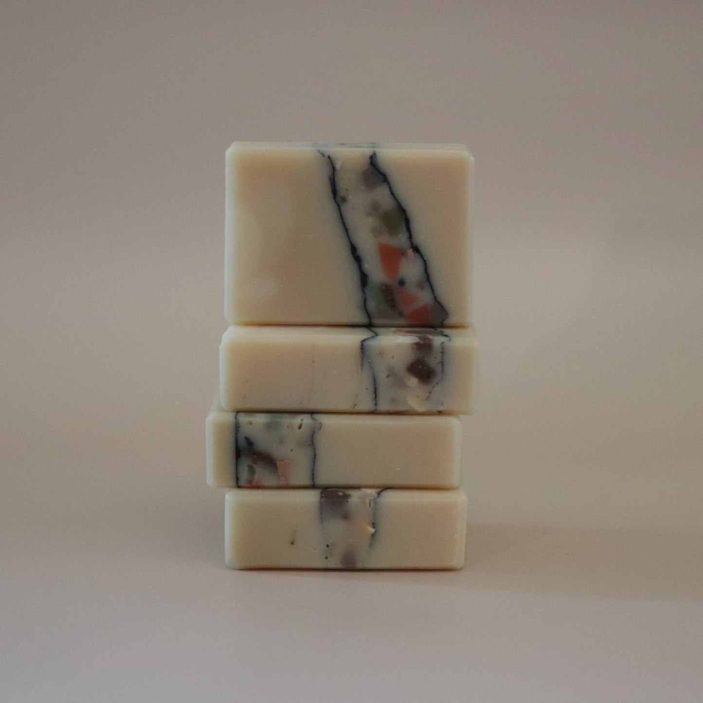 Stack of marbled soap bars on a plain background
