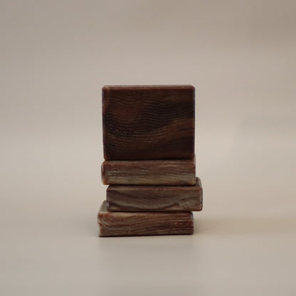 Stack of three wooden blocks soap bars on a beige background