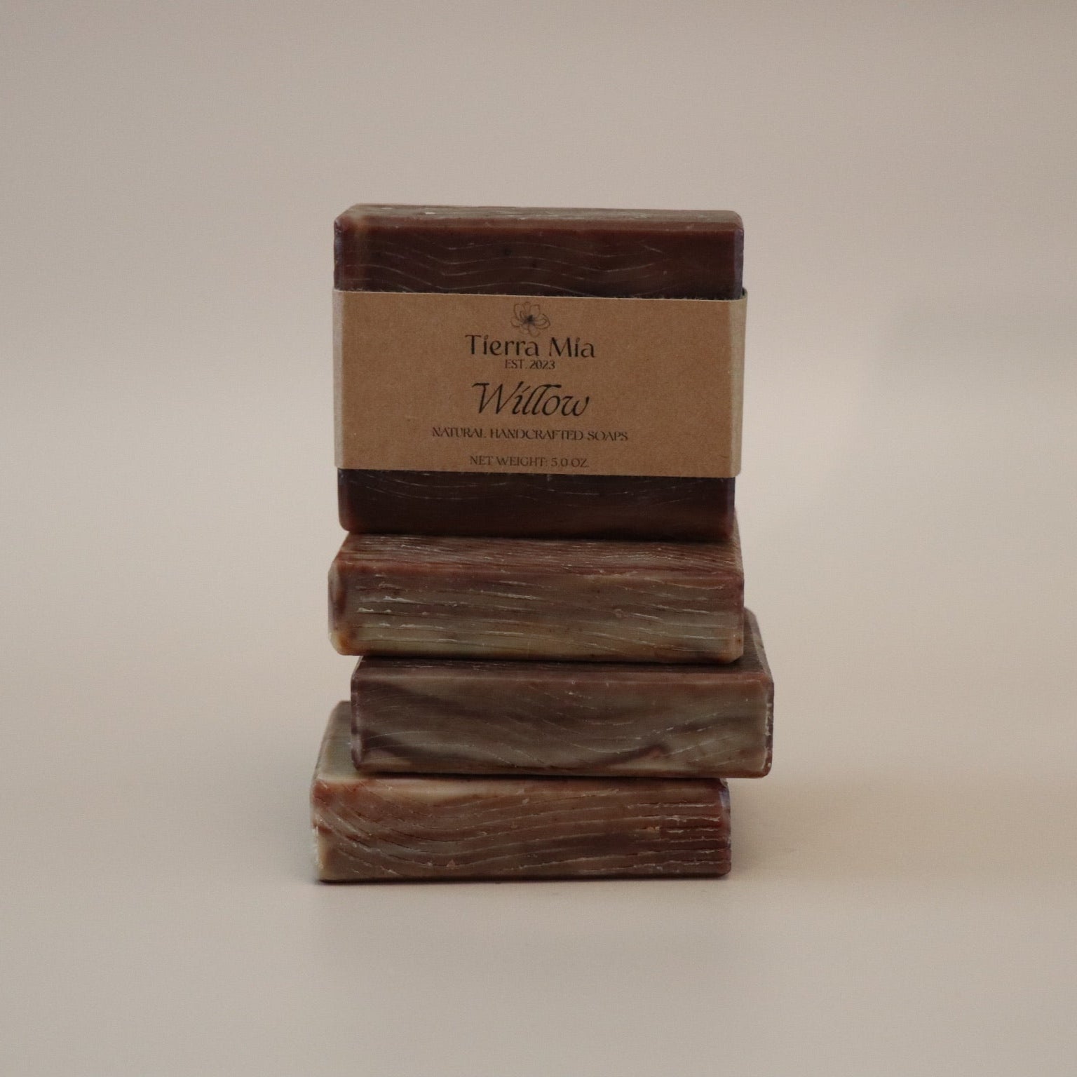Stack of three soap bars with a label on a beige background