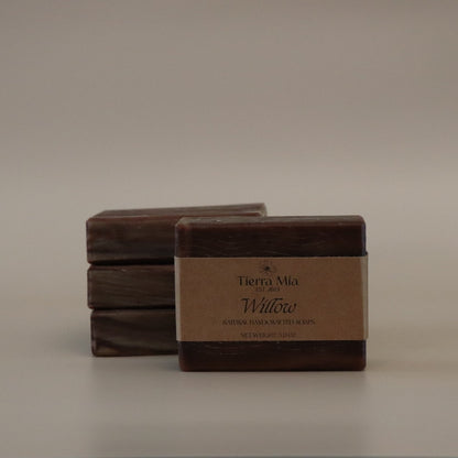 Four brown soap bars with a label on a beige background