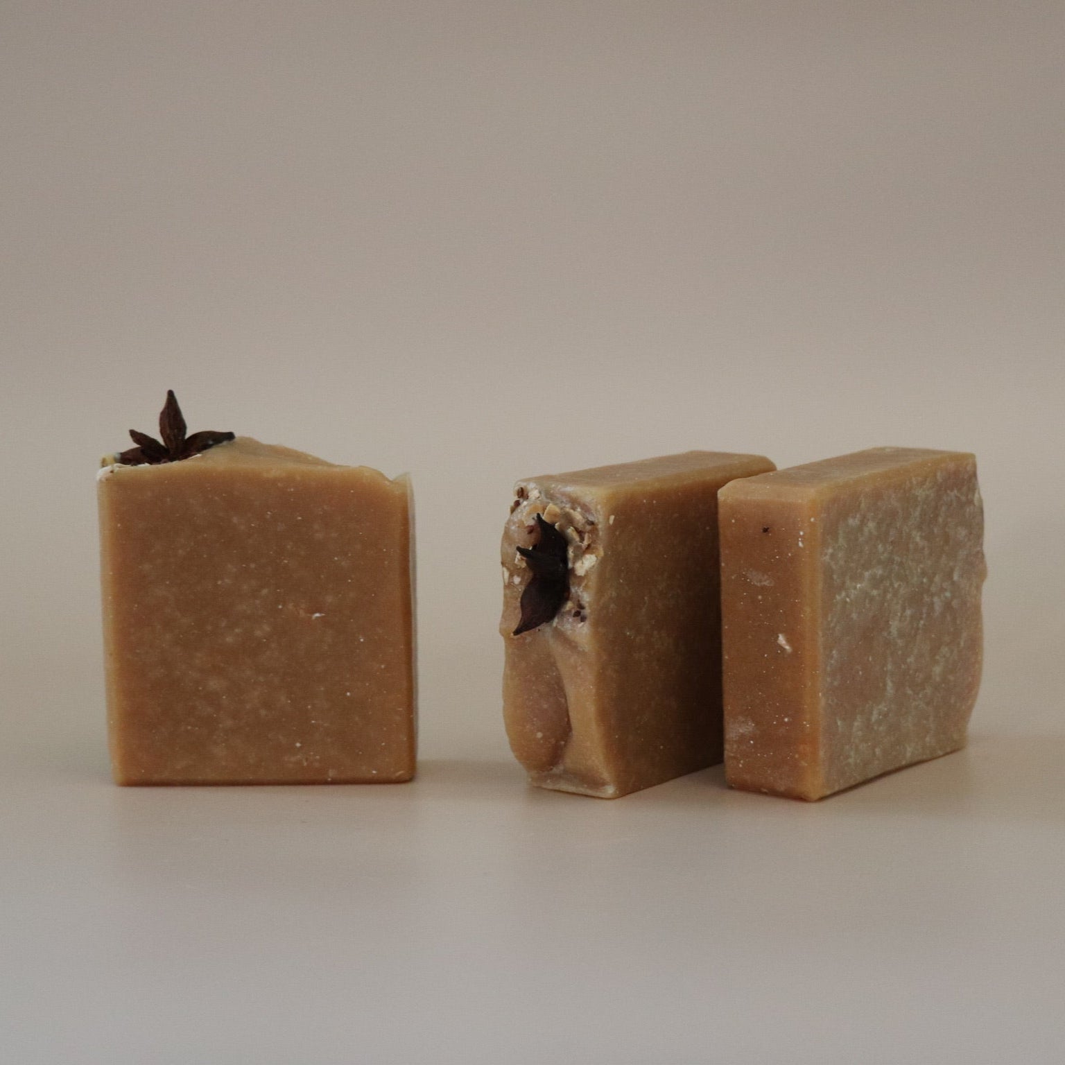 Three brown soap bars on a beige background