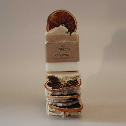 Stack of soap bars with natural elements on a beige background