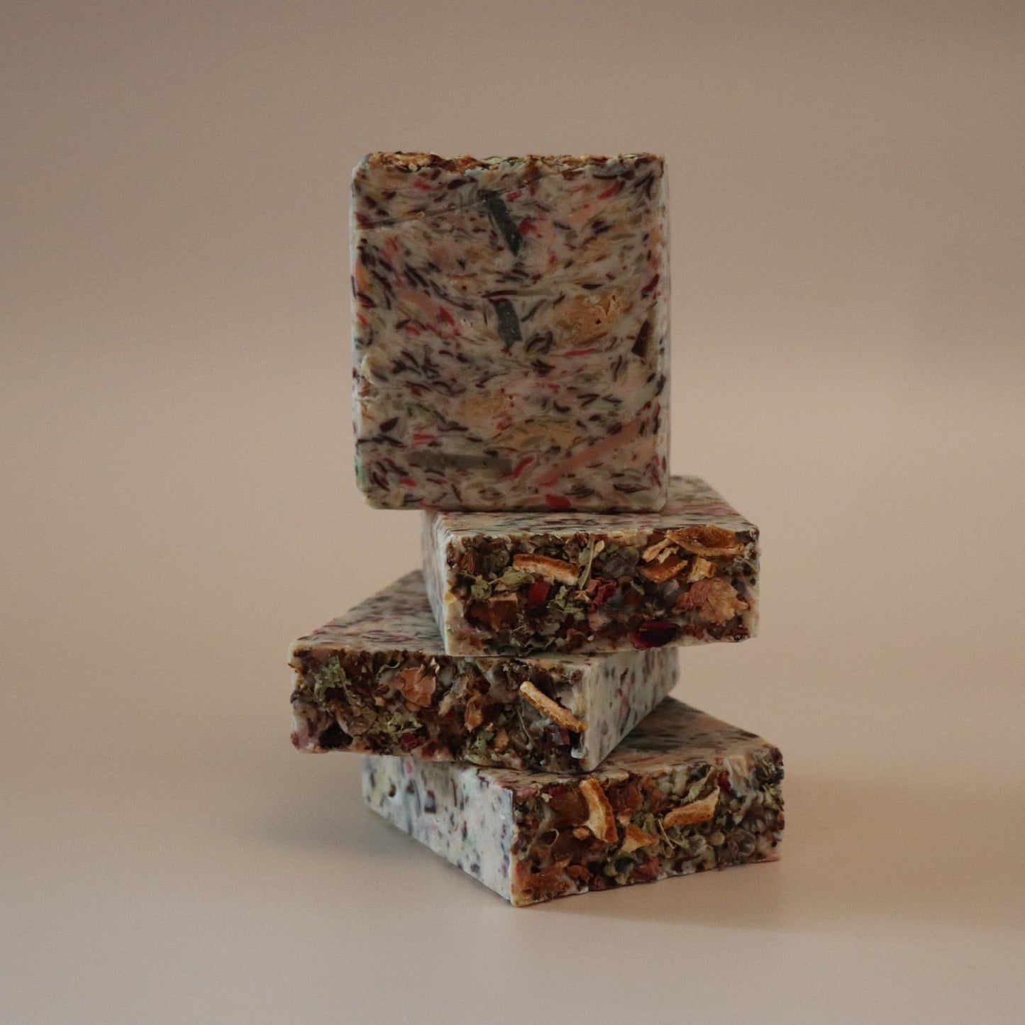 Stack of three marbled soap bars on a beige background
