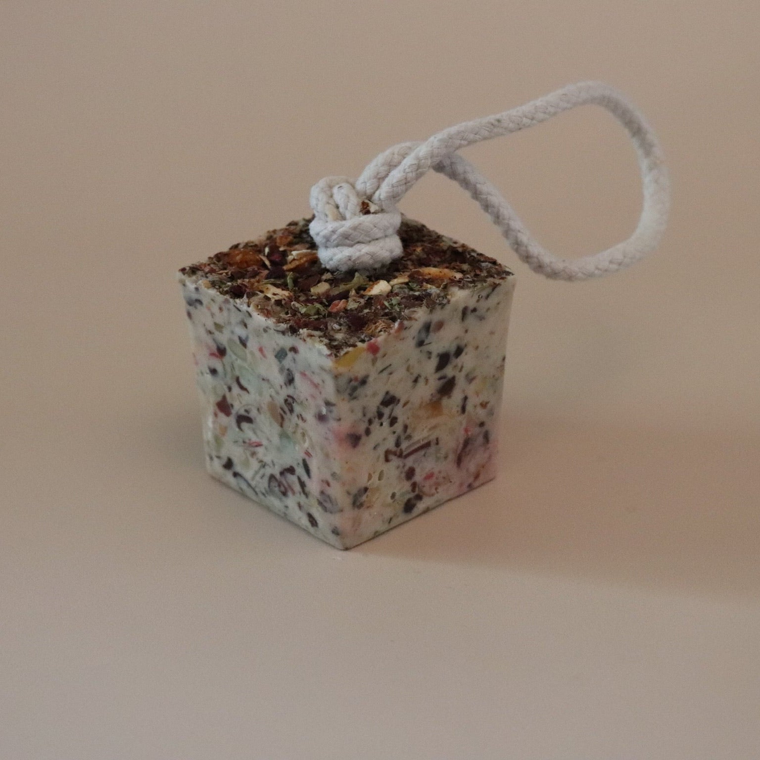 Decorative cube soap with a rope on a beige background