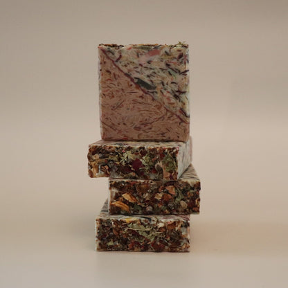 Stack of three rectangular, multicolored soap bars on a beige background