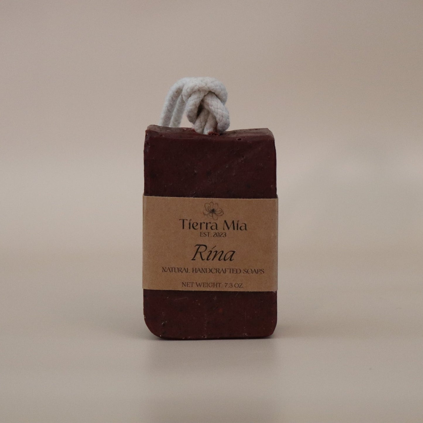 Dark Red soap bar with a rope on a beige background