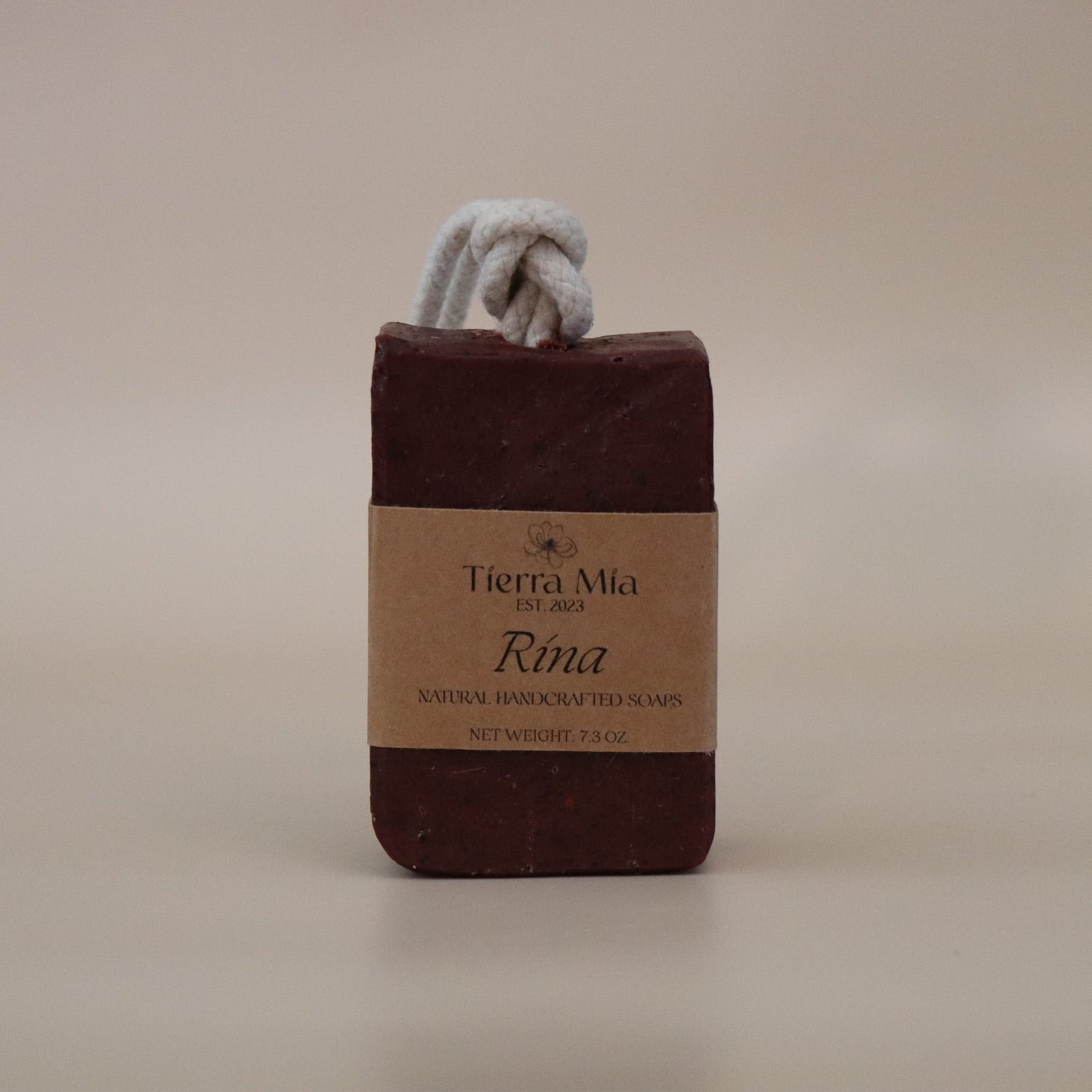 Dark Red soap bar with a rope on a beige background