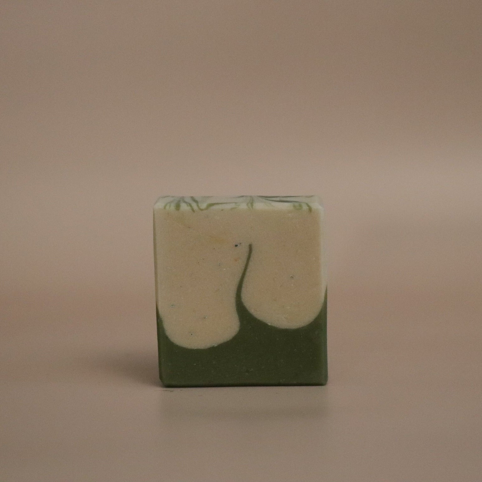 Green and white marbled soap bar on a beige background