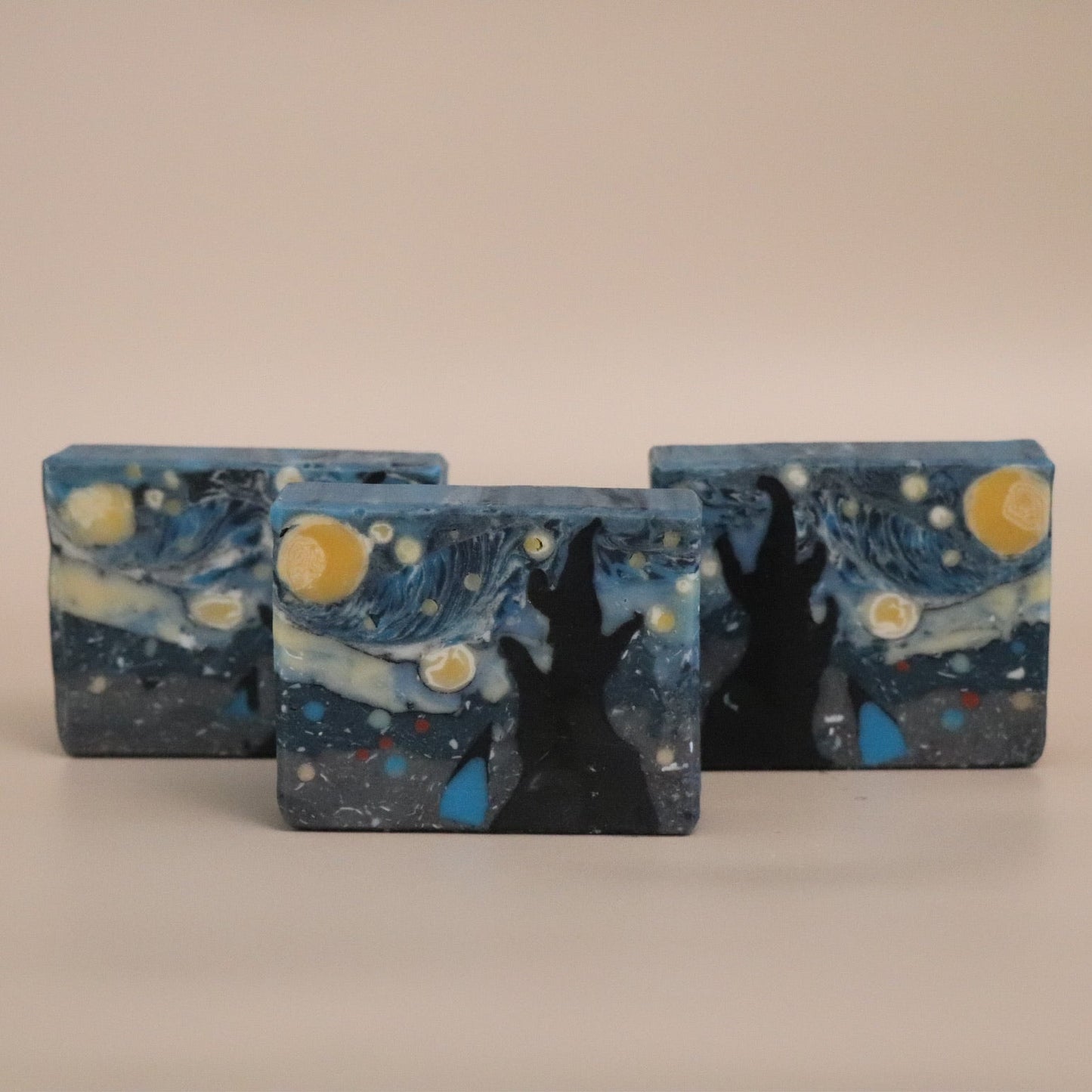 Three rectangular soap bars with a 'Starry Night' design on a beige background