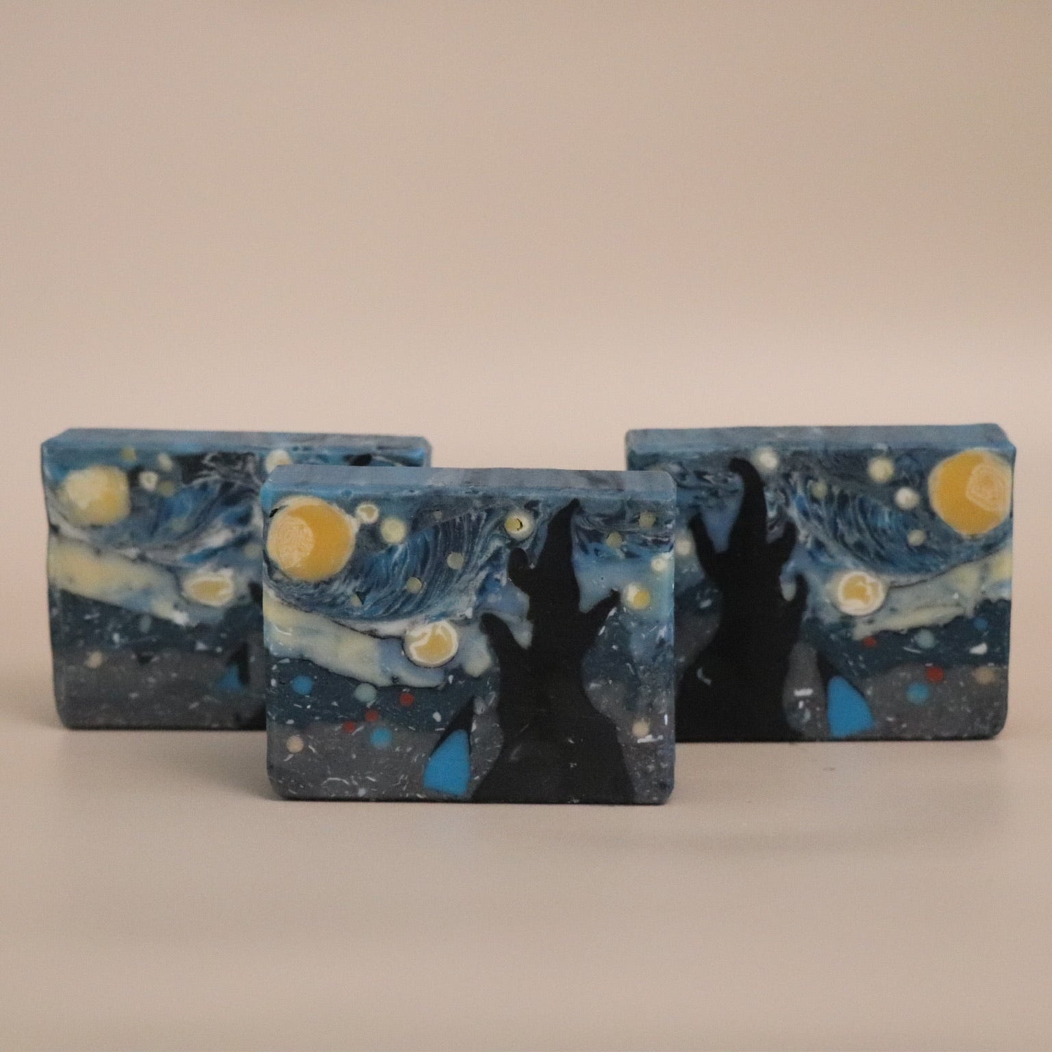 Three rectangular soap bars with a 'Starry Night' design on a beige background