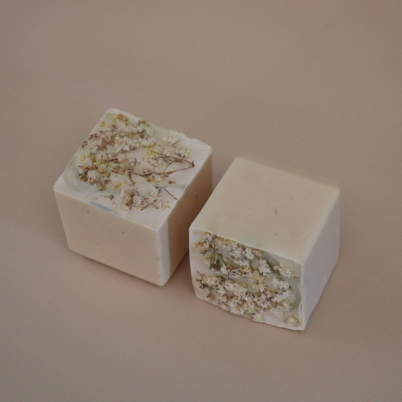 Two square blocks with floral embedded design on a beige background