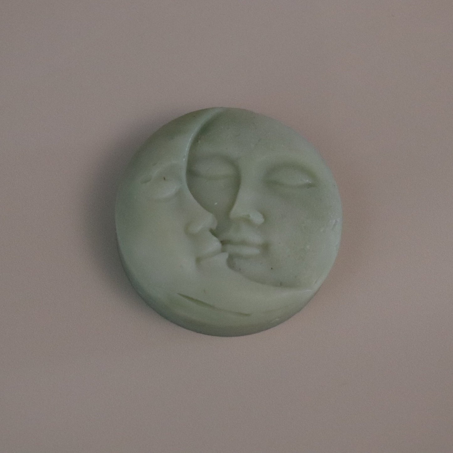 Green Moon soap with face design on a beige background