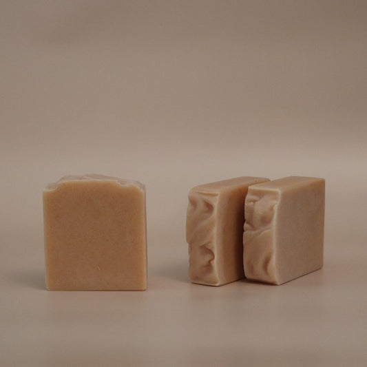Two beige soap bars on a beige background