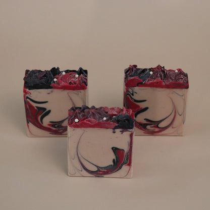 Three soap bars with a marbled design on a beige background