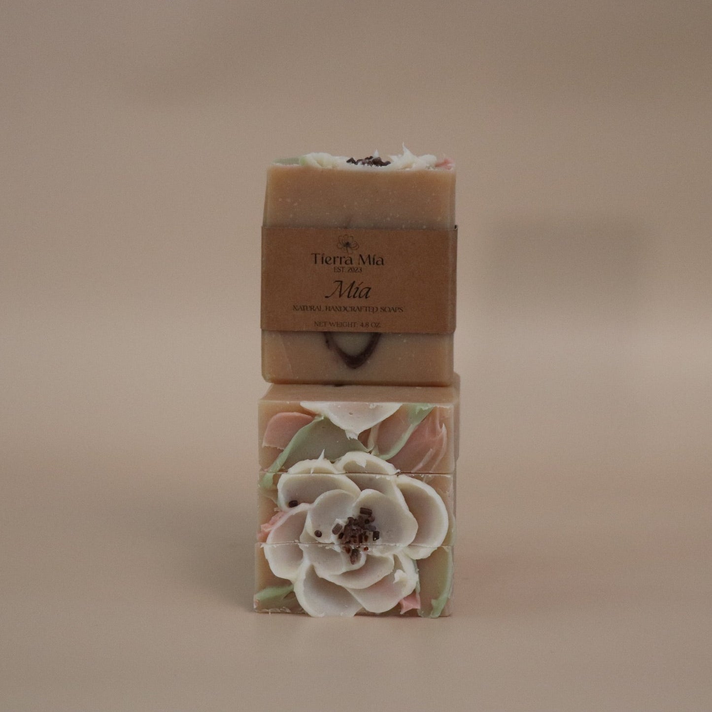 Two bars of soap with floral designs on a beige background
