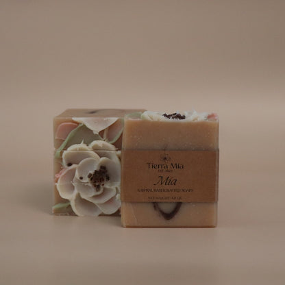 Bar of soap with floral design and branding on a beige background