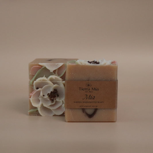 Bar of soap with floral design and branding on a beige background