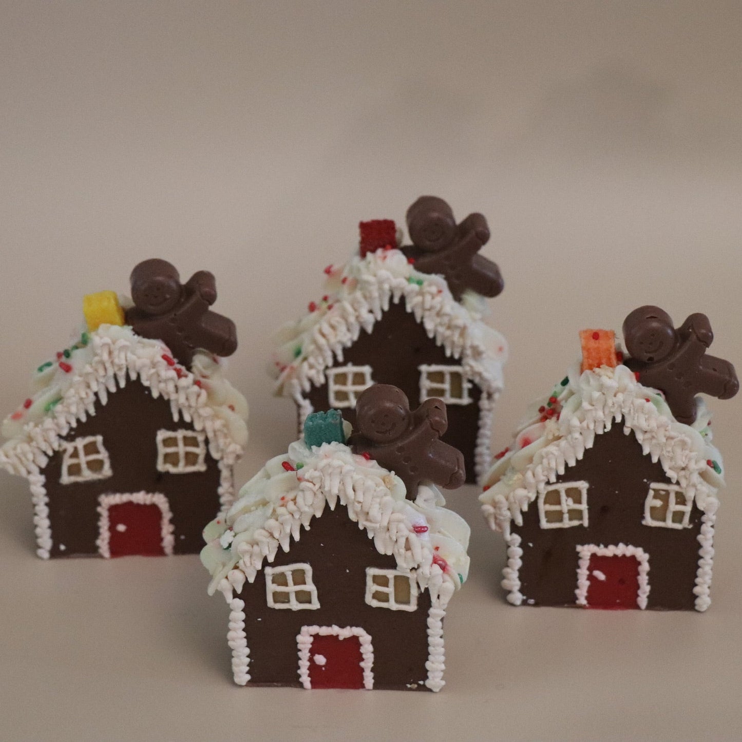 Set of small gingerbread house artisan soaps on a plain background