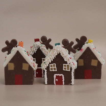 Four gingerbread house artisan soaps with decorative elements on a beige background