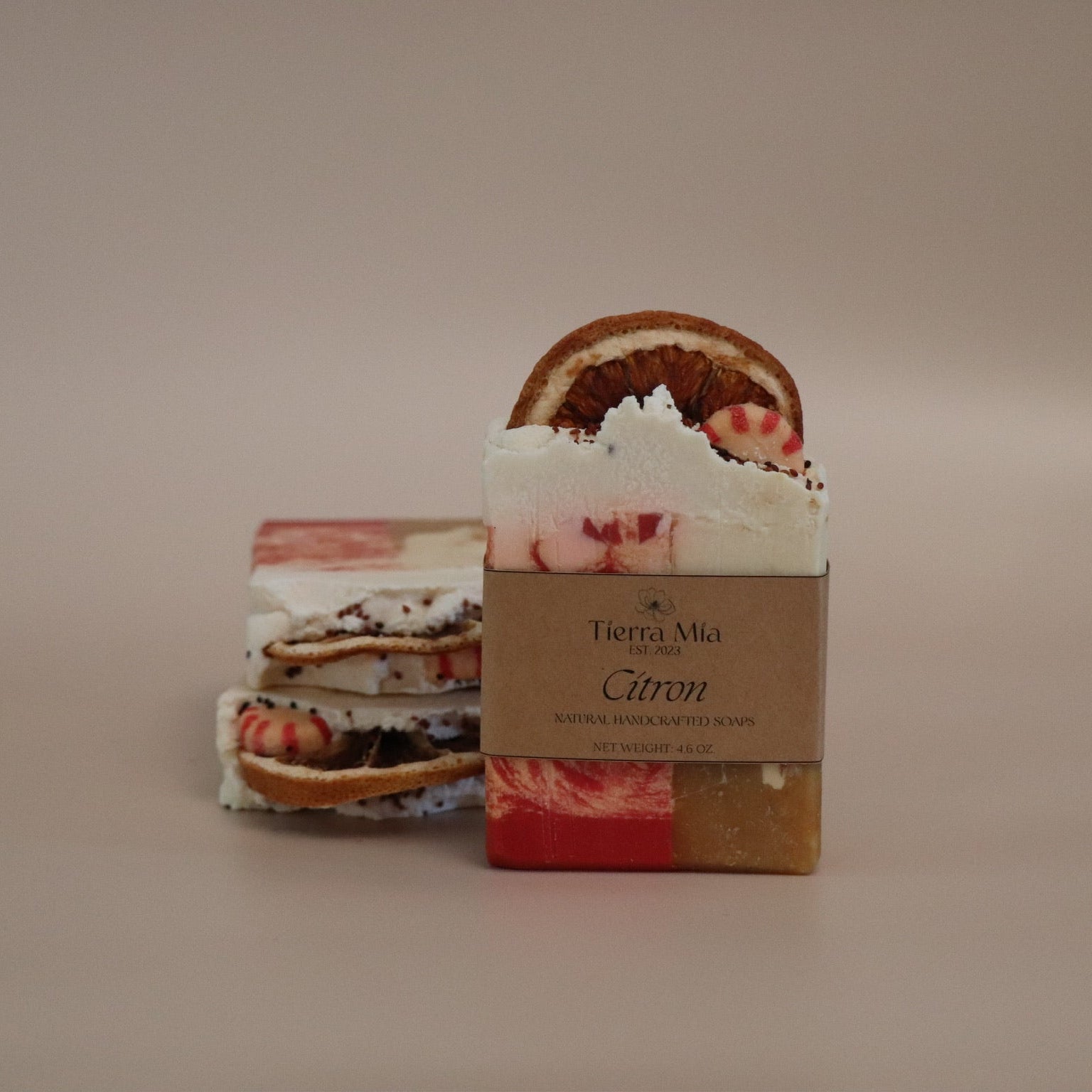 Two soap bars with decorative packaging on a beige background