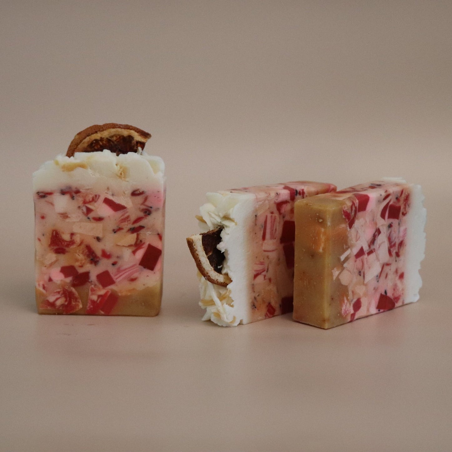 Three colorful soap bars on a beige background