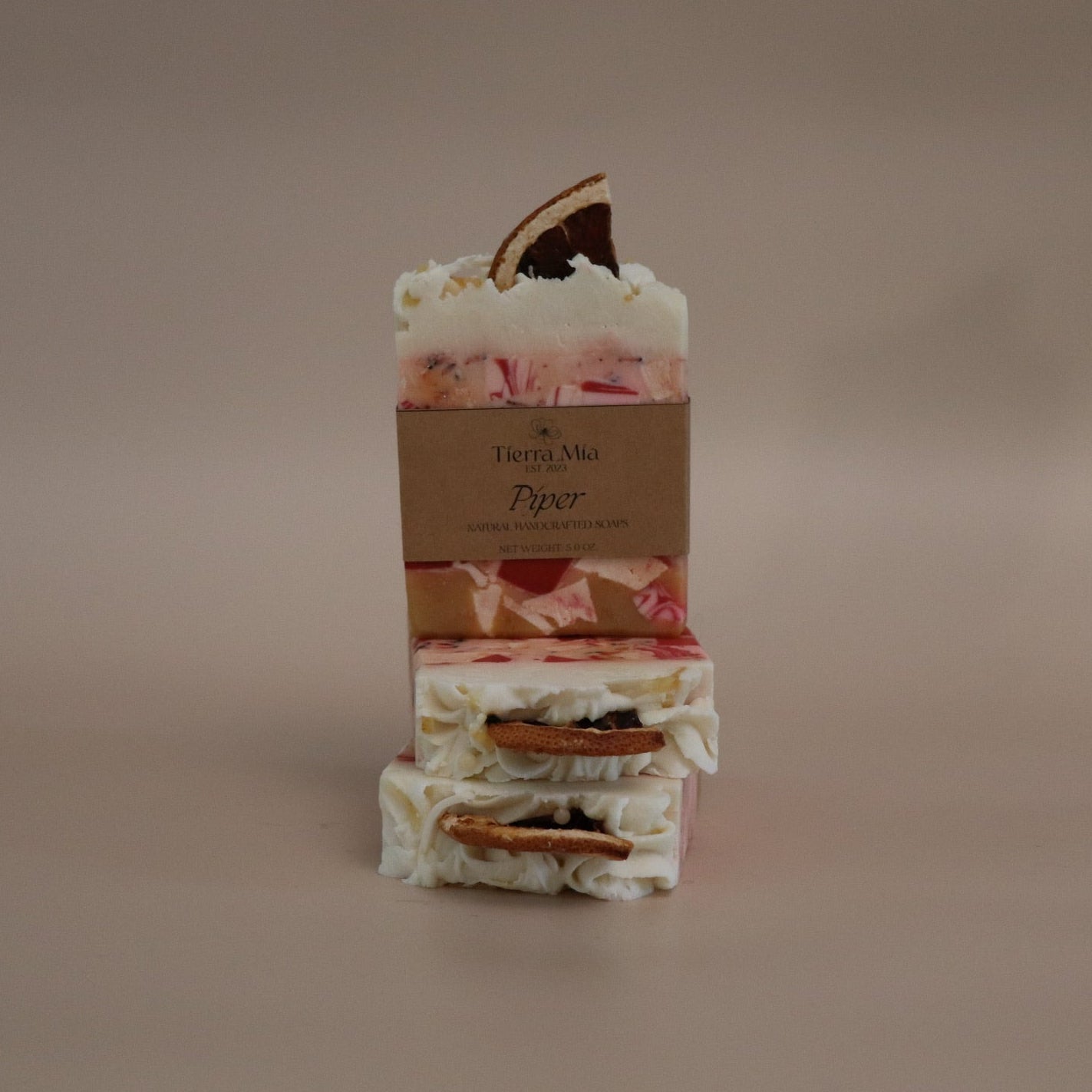 Stack of layered soap bars with a brown label on a beige background