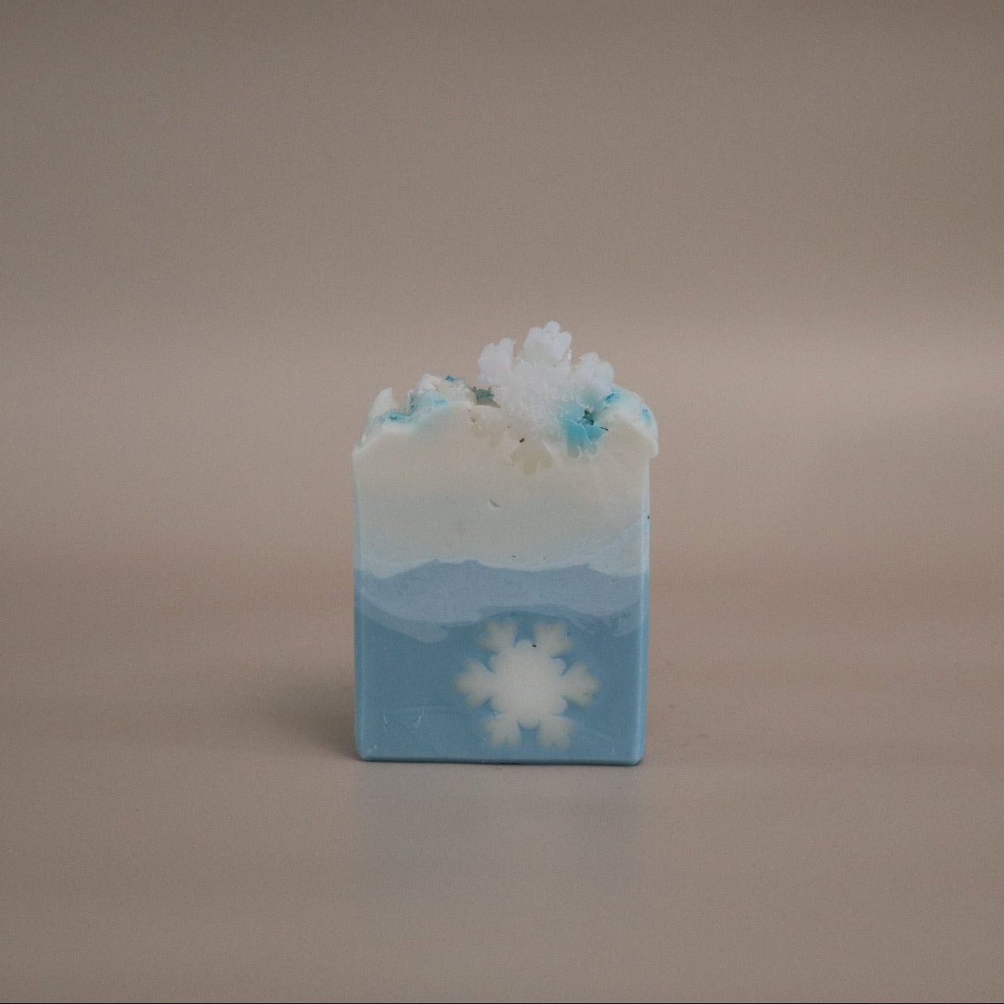 Bar of soap with a snowflake design on a beige background