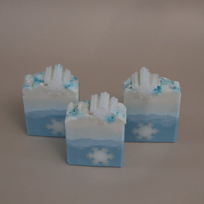 Three bars of soap with a winter design on a brown background